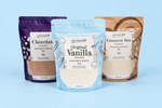 Three packages of pancake and waffle mix with different flavors on a blue background
